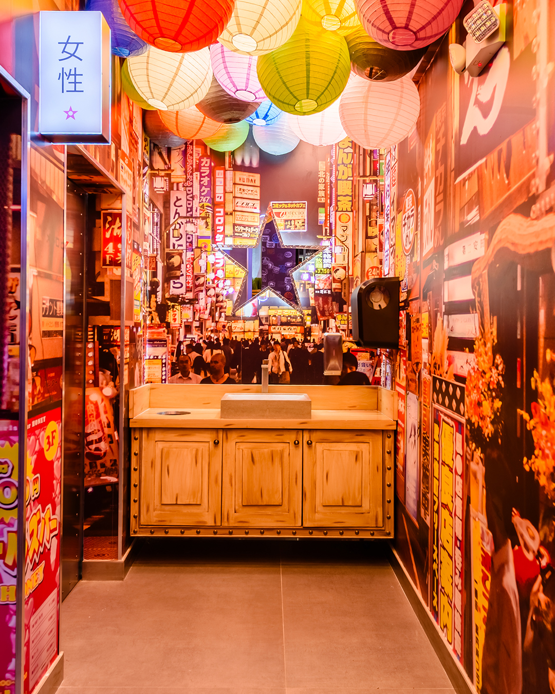 Espacio interior de Nacionsushi inspirado en una calle japonesa, con faroles de colores colgantes y mostrador de madera.