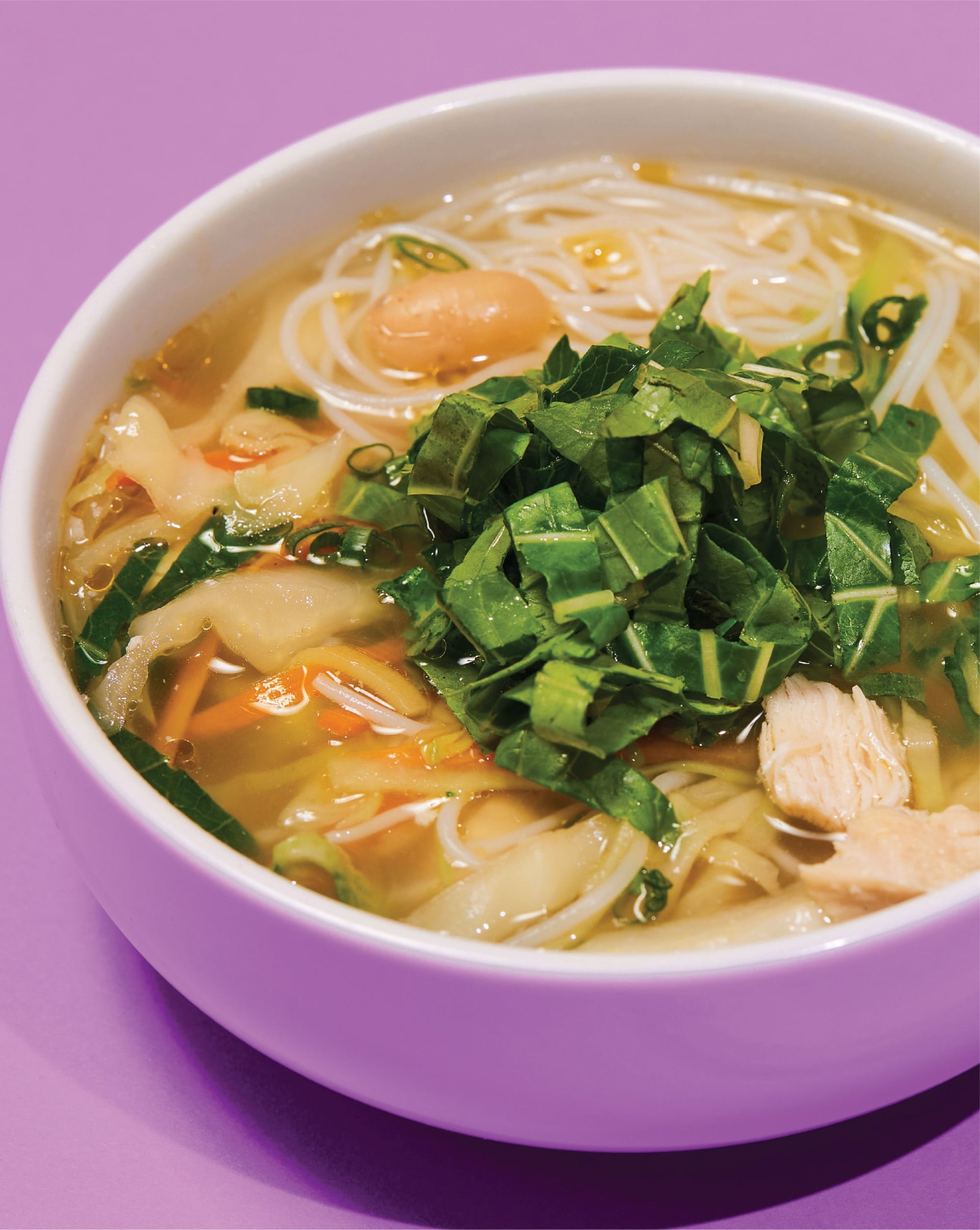 Sopa asiática de Nacionsushi con fideos de arroz, vegetales frescos y hierbas verdes en caldo caliente.